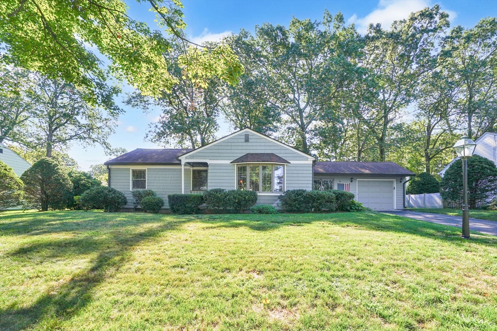a front view of a house with a yard and trees
