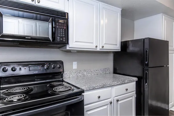 a kitchen with granite countertop a stove and a microwave