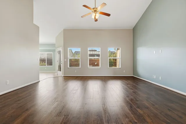 a view of a livingroom with wooden floor and a ceiling fan