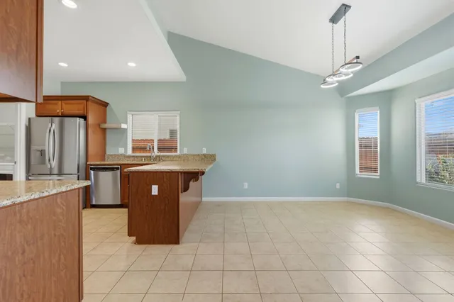 a kitchen with stainless steel appliances granite countertop a stove a sink and a refrigerator