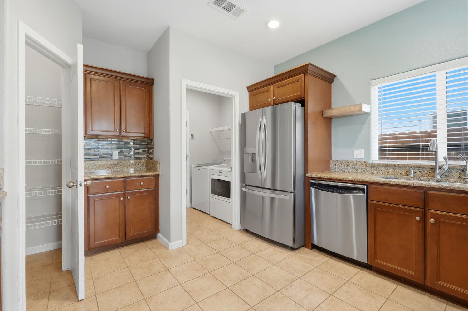 1206 North Kaplan Place Hanford, CA 93230 - Photo 25 of 52 a kitchen with granite countertop cabinets and stainless steel appliances