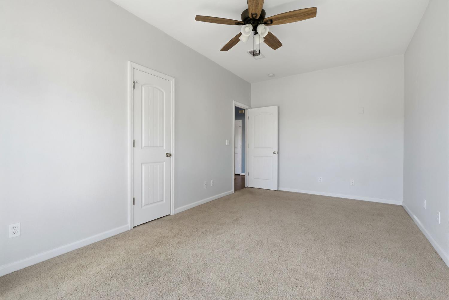 1206 North Kaplan Place Hanford, CA 93230 - Photo 34 of 52 an empty room with a ceiling fan and carpet