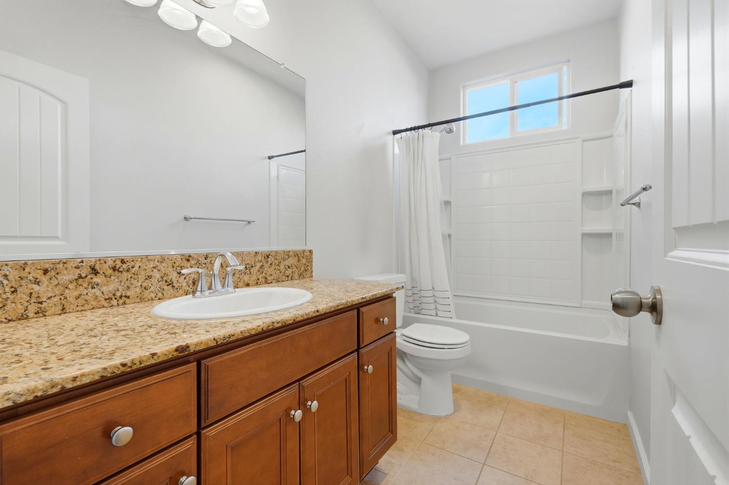 1206 North Kaplan Place Hanford, CA 93230 - Photo 35 of 52 a bathroom with a granite countertop sink toilet and shower