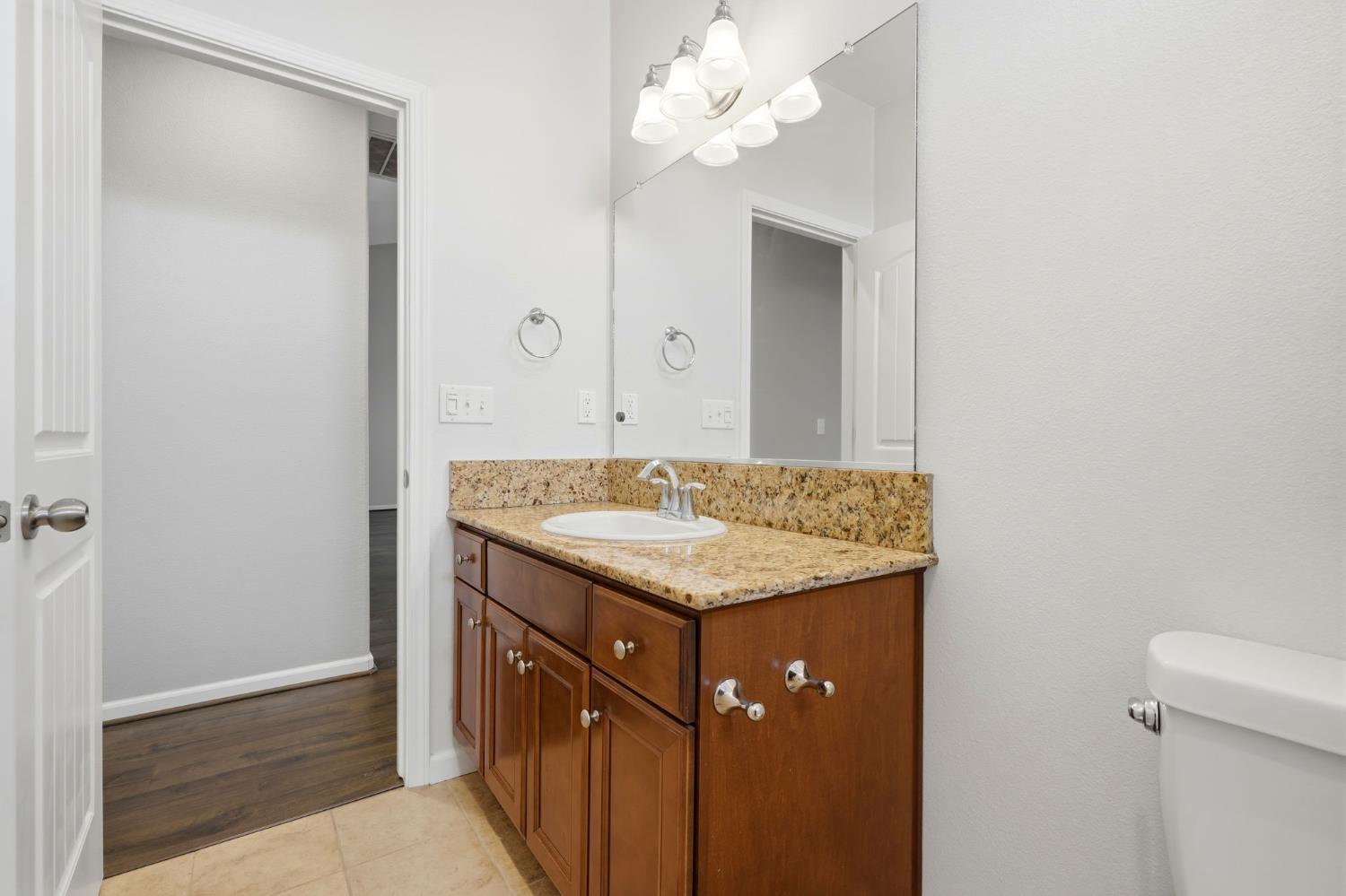1206 North Kaplan Place Hanford, CA 93230 - Photo 36 of 52 a bathroom with a granite countertop sink a large mirror and a shower