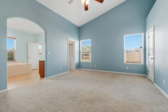 a view of an empty room and chandelier fan