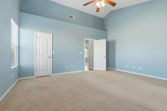 an empty room with closet and windows