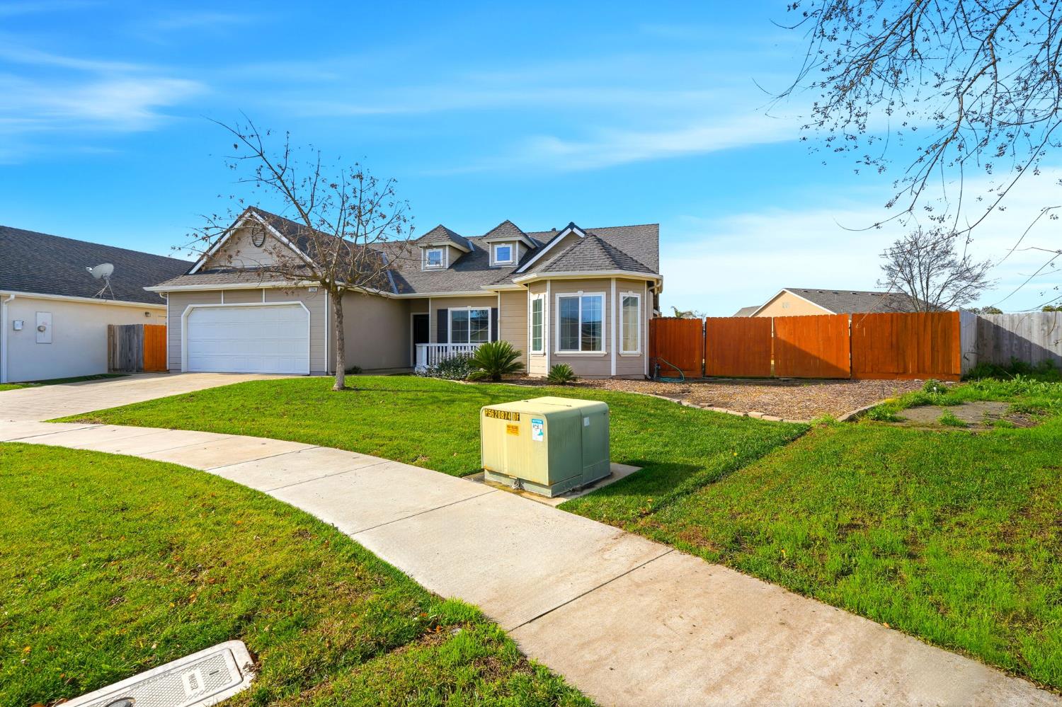 1206 North Kaplan Place Hanford, CA 93230 - Photo 4 of 52 a front view of a house with a yard and potted plants