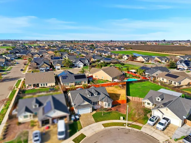 an aerial view of a houses with a swimming pool