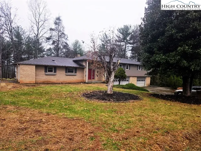a front view of a house with a yard garage and outdoor seating
