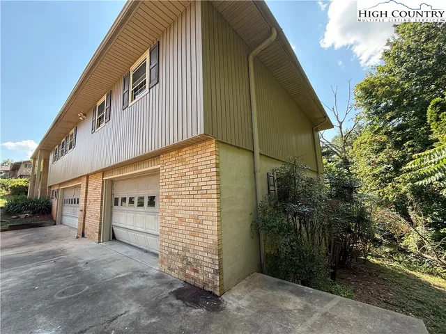 a front view of a house with plants and garage
