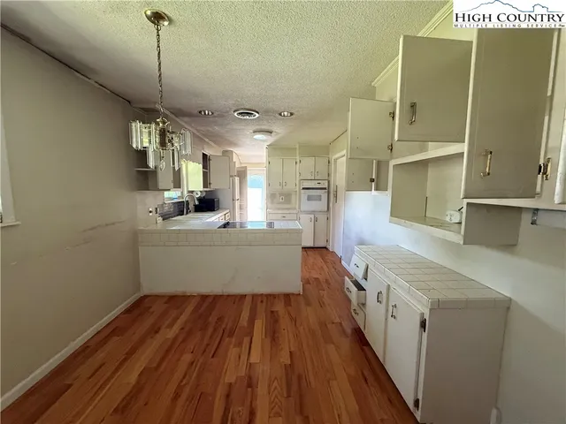 a view of a kitchen with wooden floor and windows