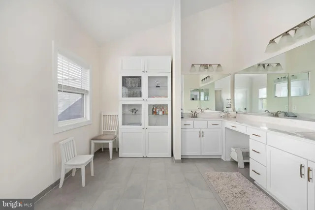a bedroom with a bed a desk and chair with the large windows