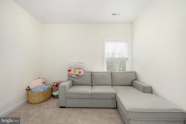a living room with painting on the wall and a window