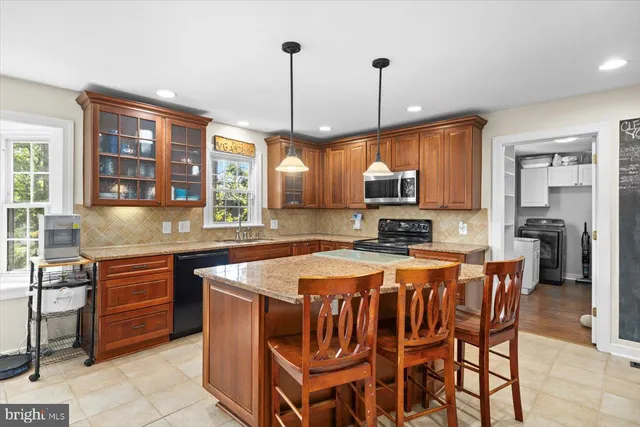 a kitchen with a stove a sink a microwave a dining table and chairs