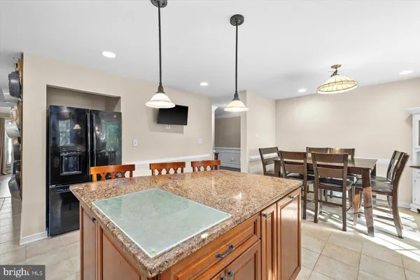 a kitchen with a stove a kitchen island a table and chairs