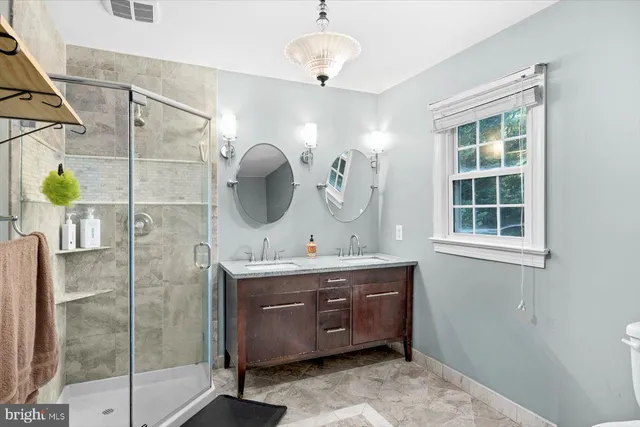 a bathroom with a double vanity sink mirror and shower