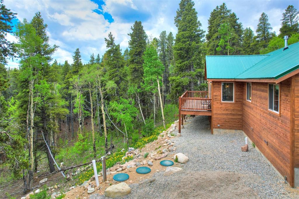 1002 Venture Road Fairplay, CO 80440 - Photo 24 of 35 a backyard of a house with table and chairs potted plants with wooden floor and fence