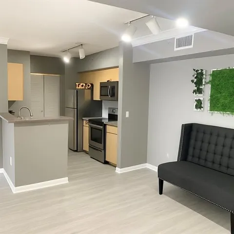 a kitchen with stainless steel appliances kitchen island granite countertop a refrigerator and a sink