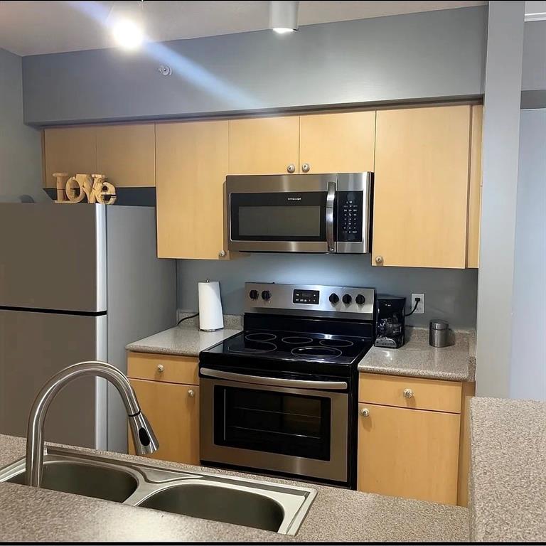 1919 Van Buren Street, Unit 609 Hollywood, FL 33020 - Photo 8 of 15 a kitchen with a microwave a stove and a sink