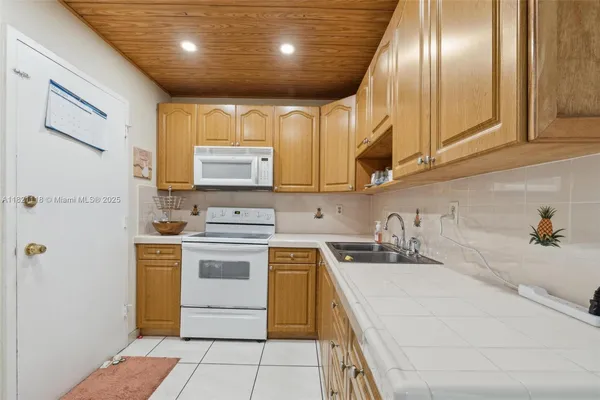 a kitchen with a stove sink and cabinets