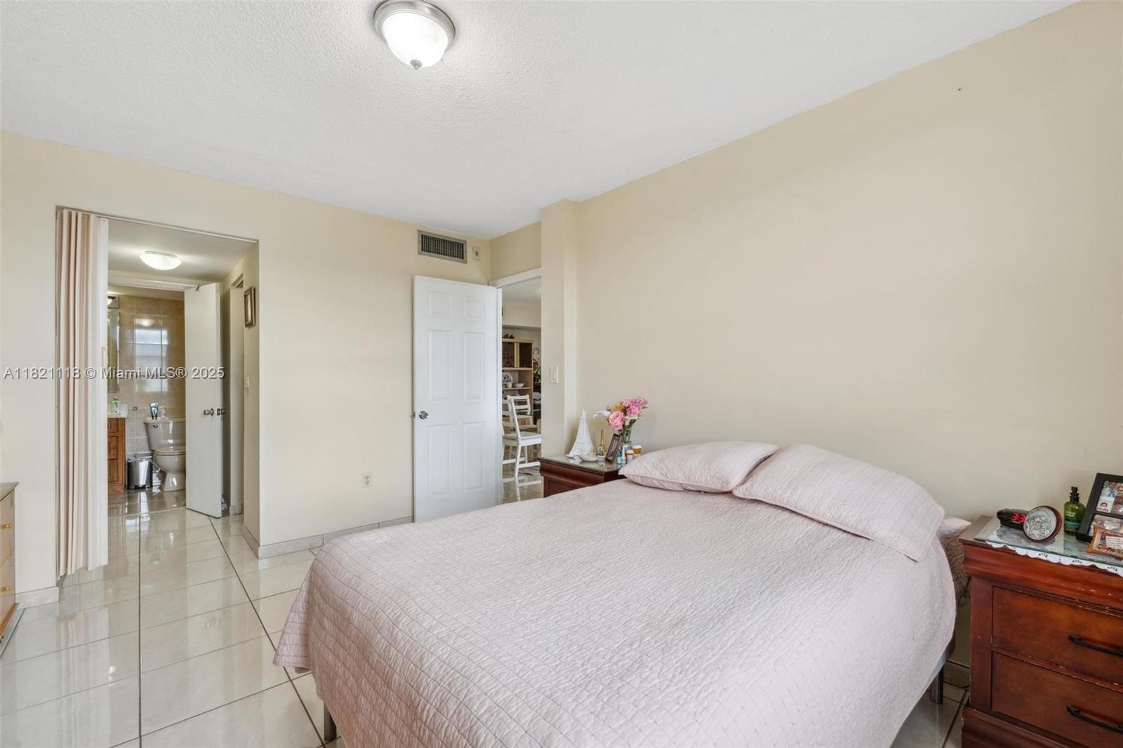 6705 Northwest 169th Street, Unit C310 Hialeah, FL 33015 - Photo 16 of 26 a bedroom with a bed and cabinets