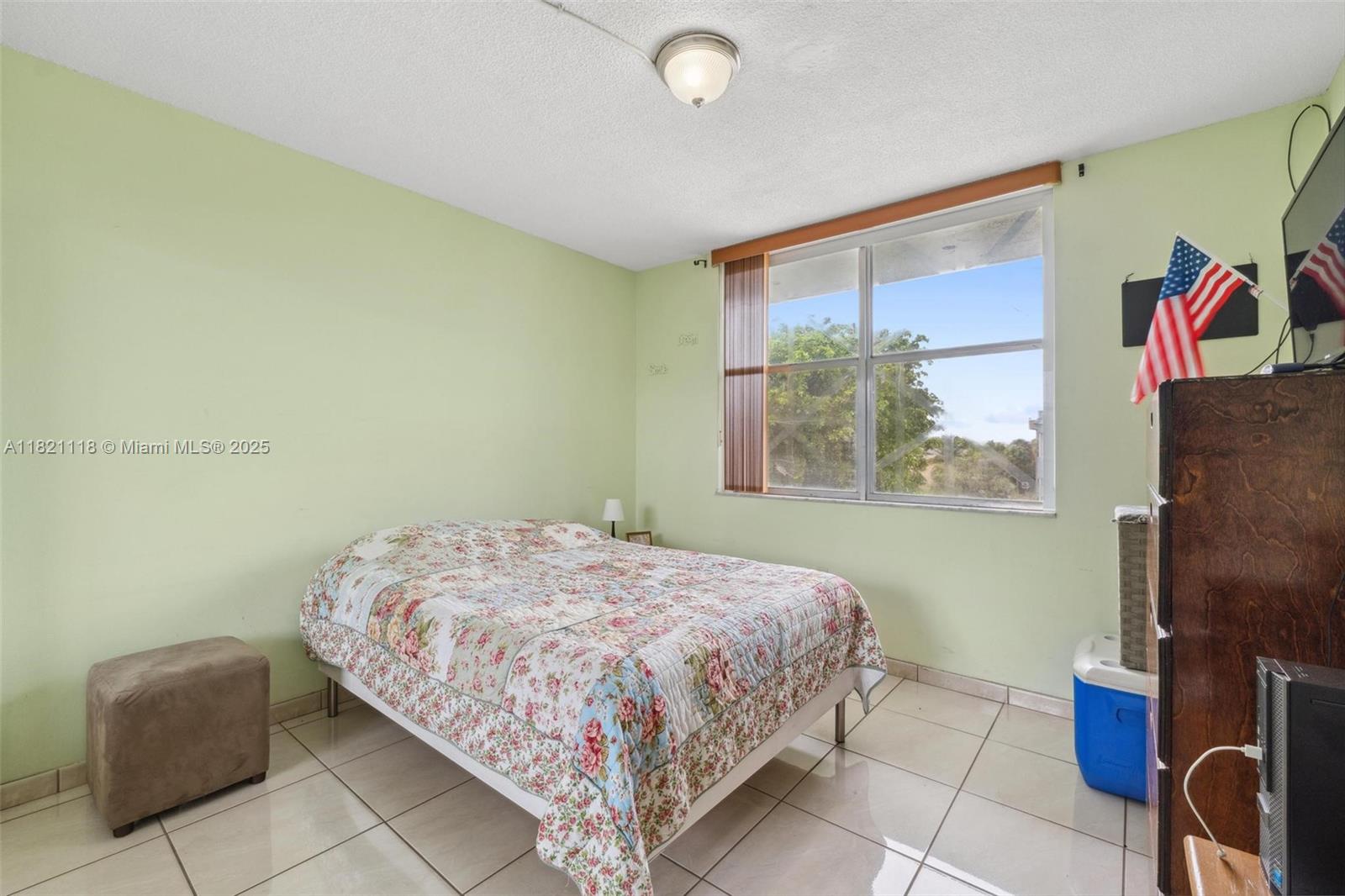 6705 Northwest 169th Street, Unit C310 Hialeah, FL 33015 - Photo 17 of 26 a bedroom with a bed and a painting on the wall