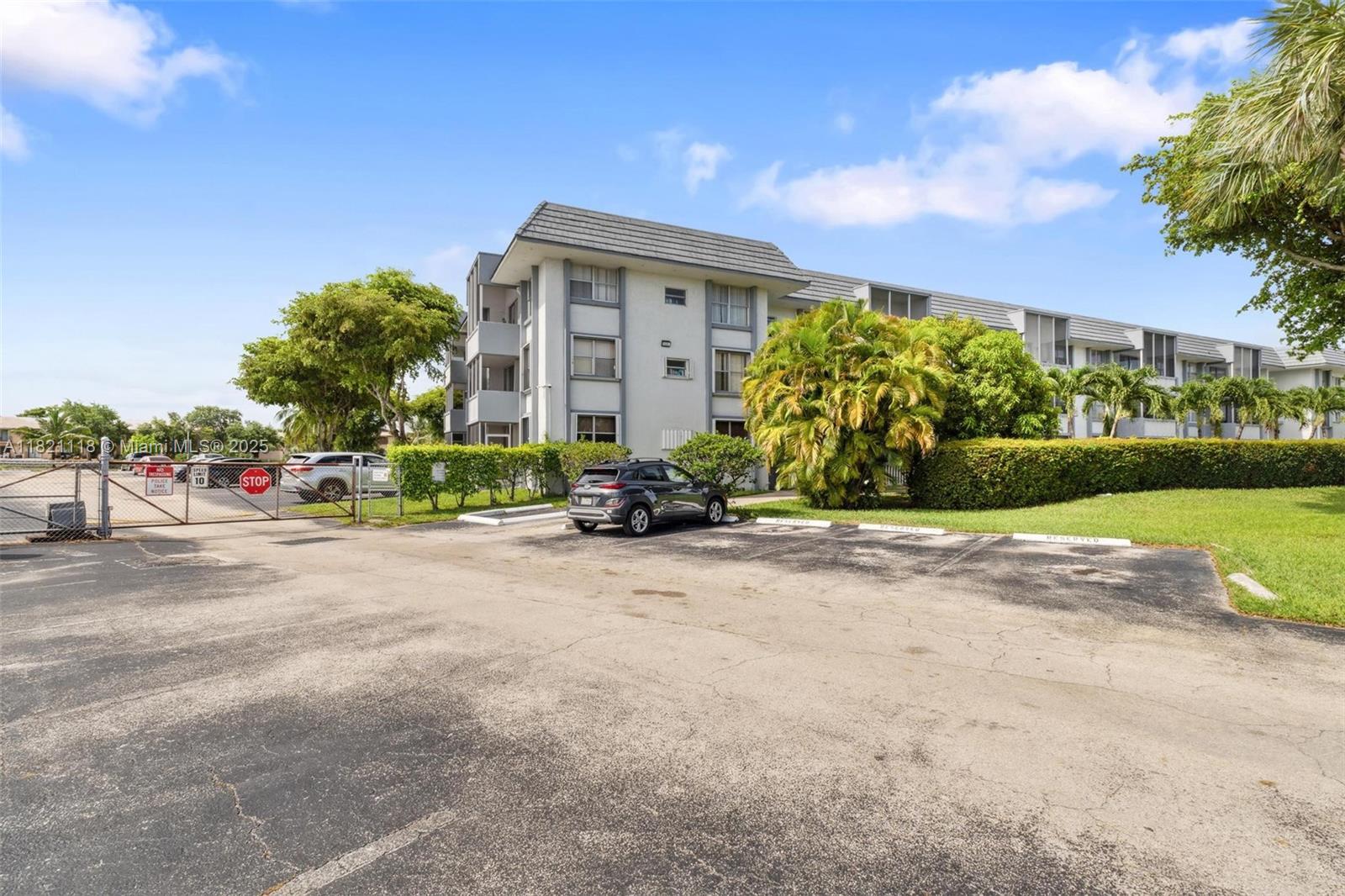 6705 Northwest 169th Street, Unit C310 Hialeah, FL 33015 - Photo 2 of 26 a front view of a house with a garden