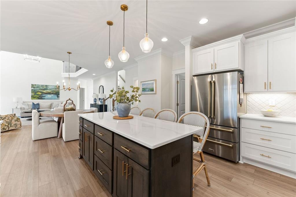 6998 Britt Gailey Road Clermont, GA 30527 - Photo 24 of 92 a kitchen with a refrigerator a sink dishwasher and wooden cabinets with wooden floor
