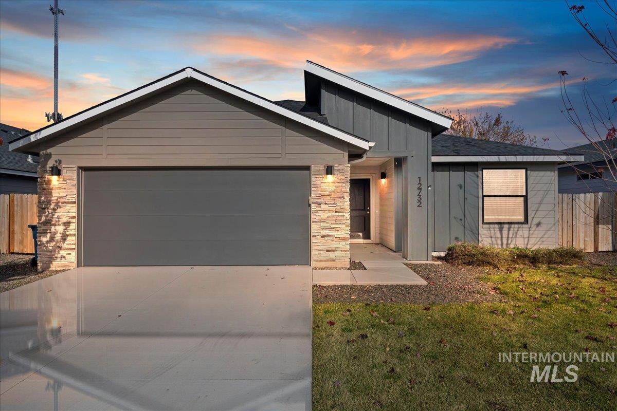 View of front of house with board and batten siding, concrete driveway, and an attached garage