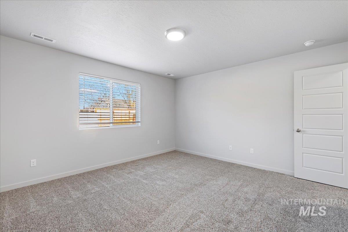12732 West Fig Street Boise, ID 83713 - Photo 21 of 34 Unfurnished room featuring light carpet and a textured ceiling