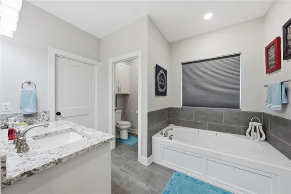 a bathroom with a tub sink and mirror