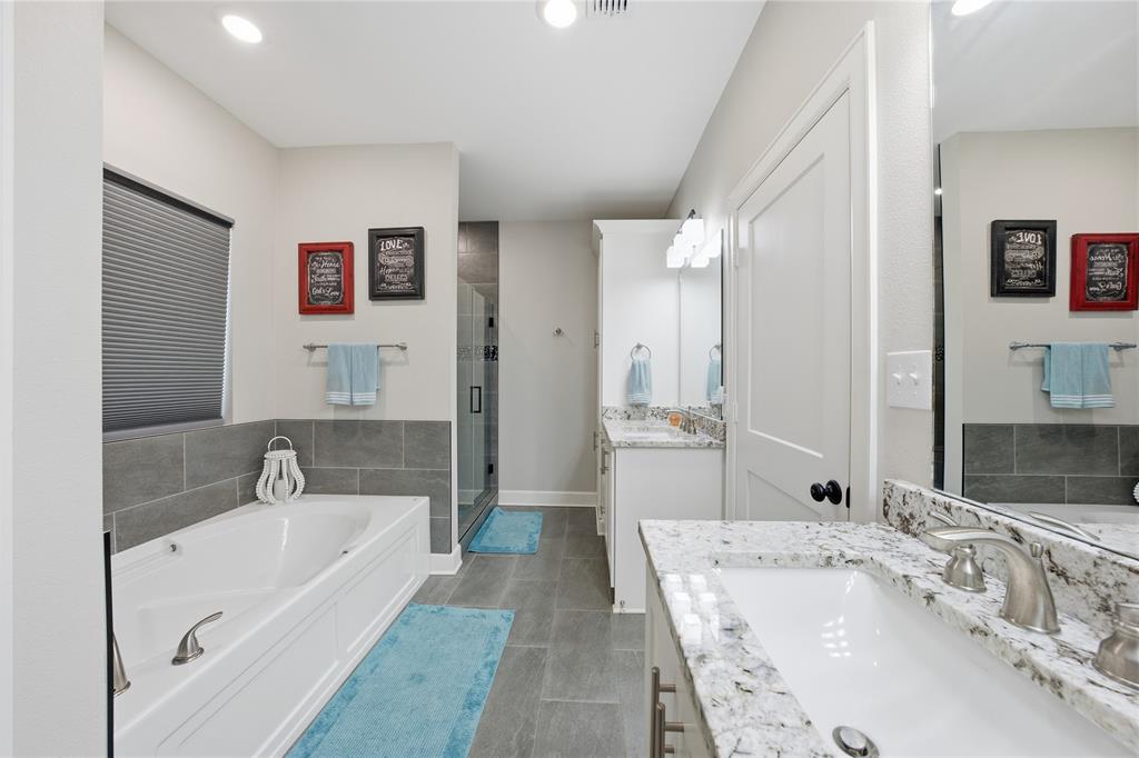 7222 Neches Street Athens, TX 75752 - Photo 17 of 27 a bathroom with a tub a sink and a large mirror