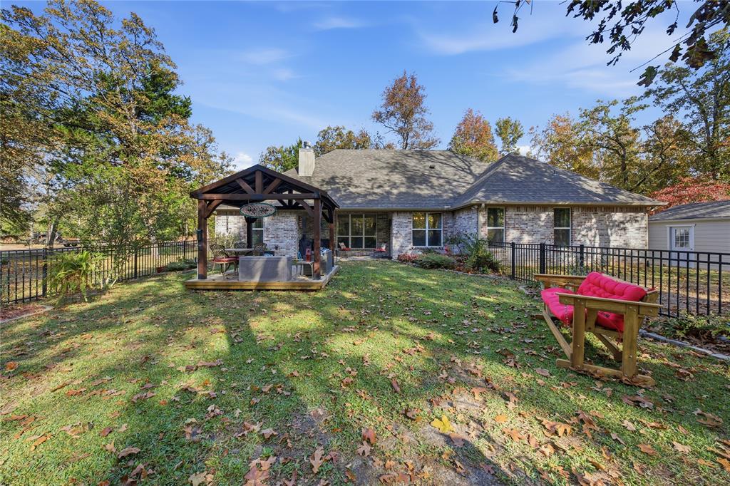 7222 Neches Street Athens, TX 75752 - Photo 19 of 27 a view of a house with a backyard