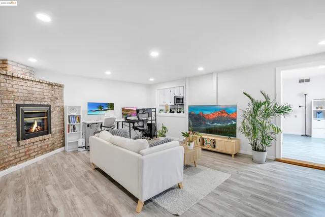 a living room with furniture a fireplace and a flat screen tv