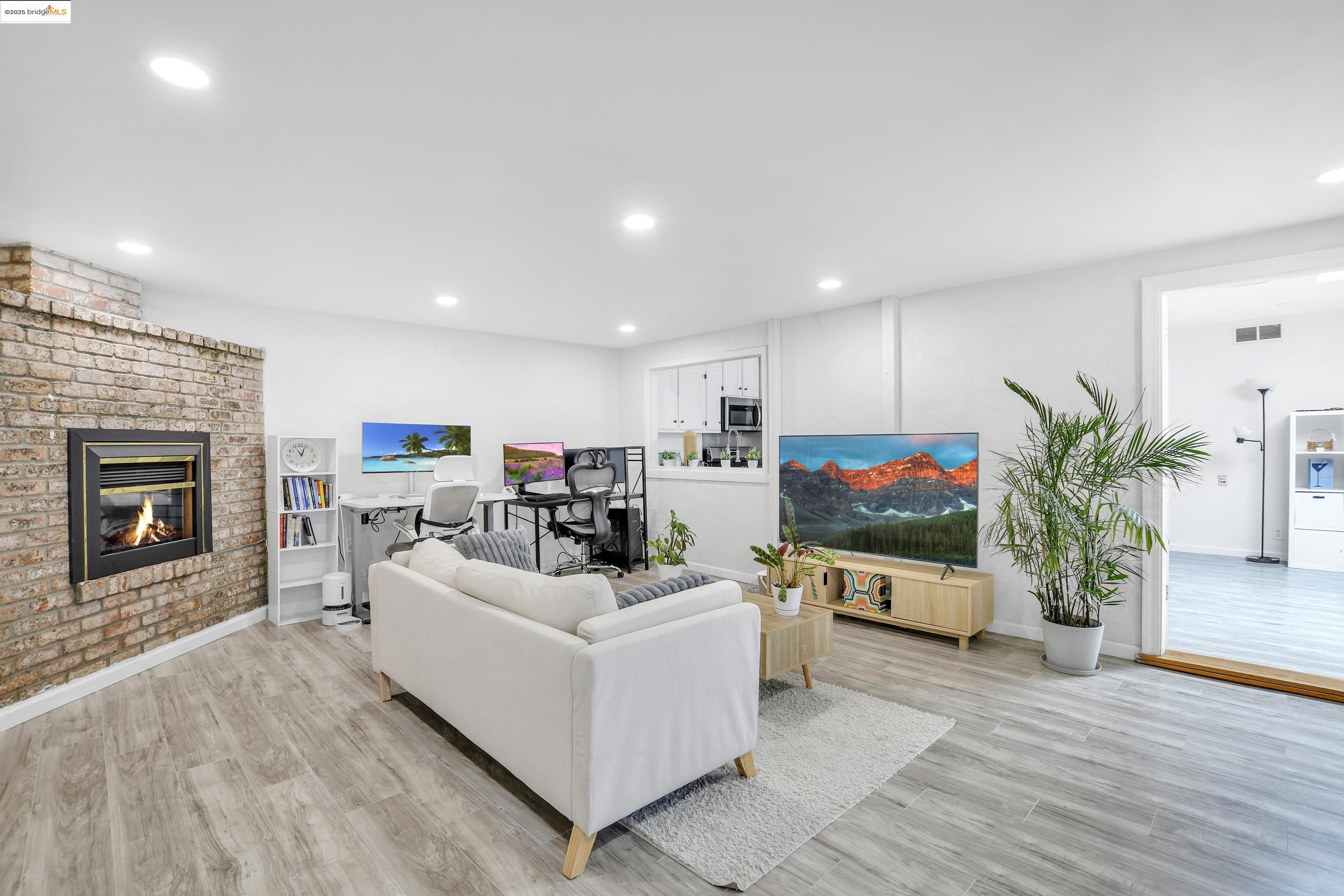 a living room with furniture a fireplace and a flat screen tv