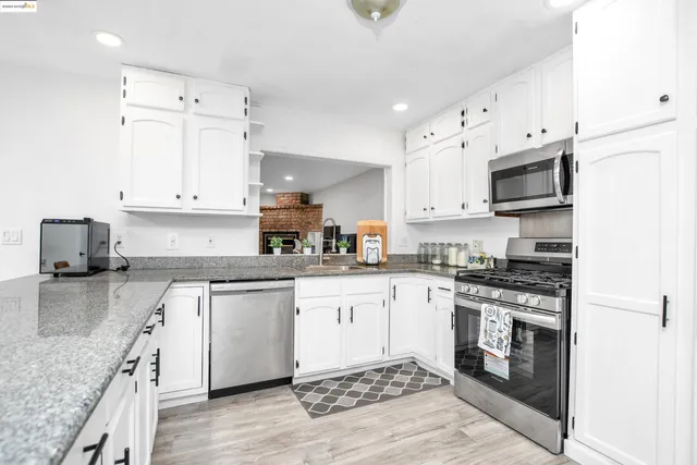 a kitchen with granite countertop a stove top oven sink and cabinets