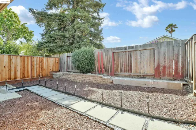 a view of a backyard with wooden fence