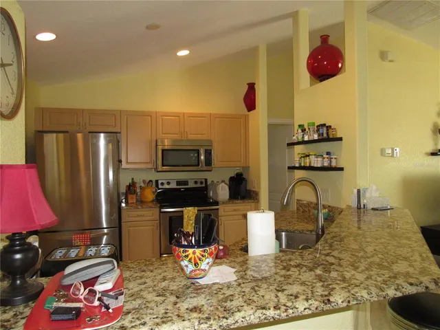 a kitchen with stainless steel appliances granite countertop a sink stove and refrigerator