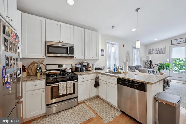 a kitchen with stainless steel appliances a sink stove top oven and cabinets
