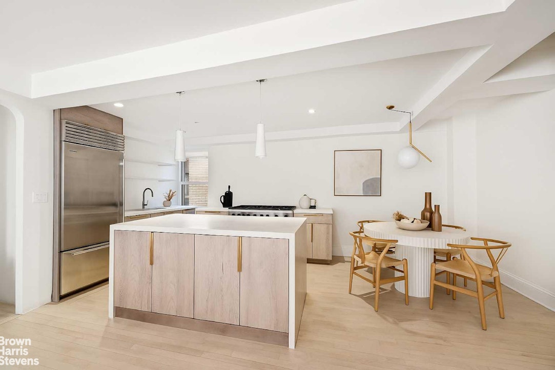 433 East 51st Street, Unit 9A Manhattan, NY 10022 - Photo 3 of 19 a kitchen with a stove a table and chairs in it