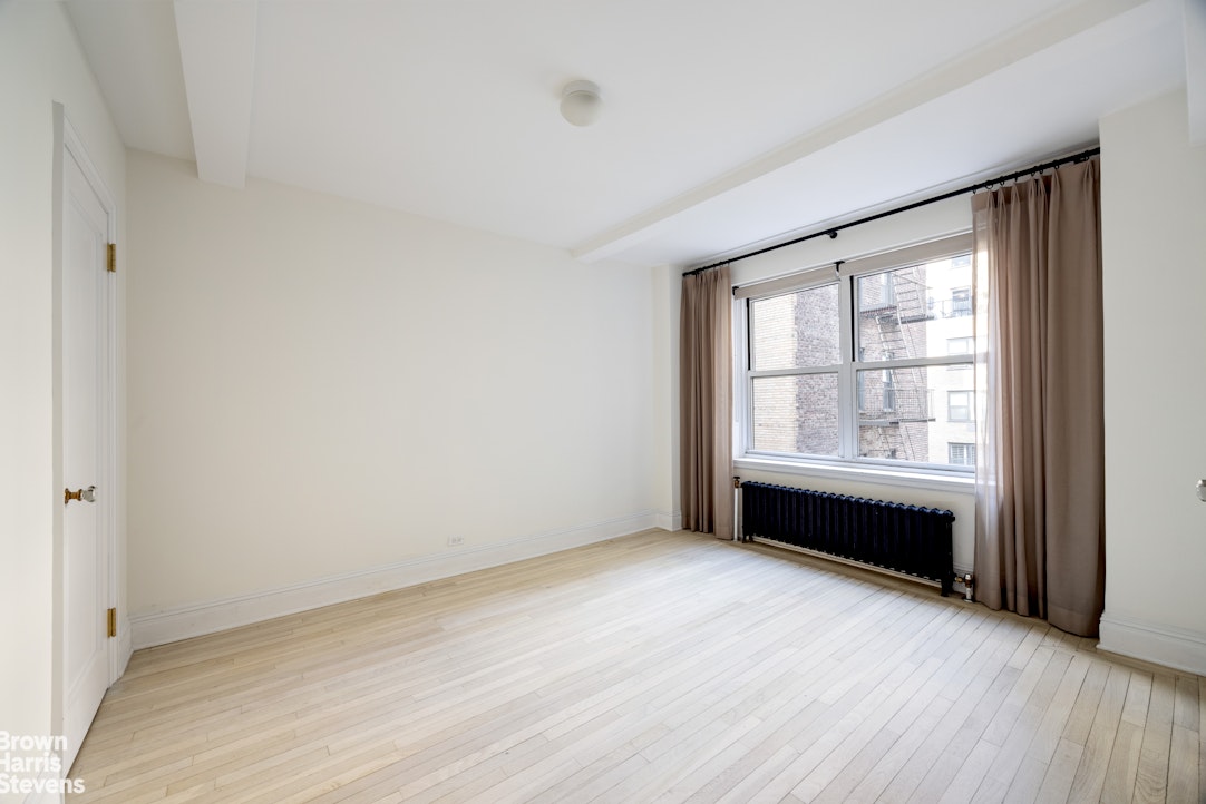 433 East 51st Street, Unit 9A Manhattan, NY 10022 - Photo 8 of 19 an empty room with wooden floor and windows