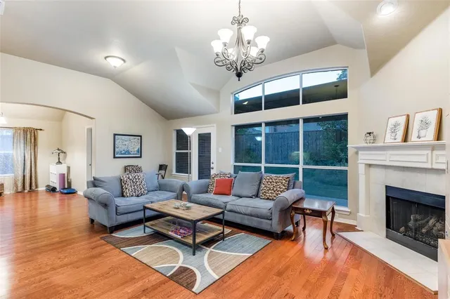 a living room with furniture a chandelier and a fireplace