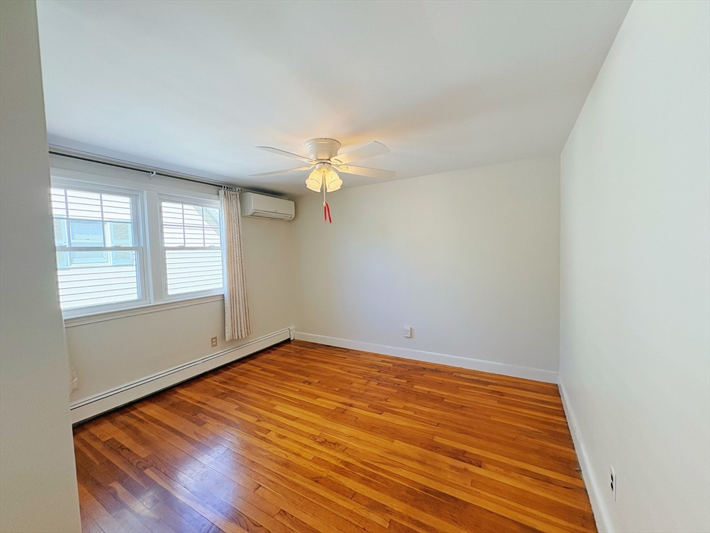 55 Sutherland Road, Unit 55 Arlington, MA 02476 - Photo 10 of 23 wooden floor in an empty room with a window