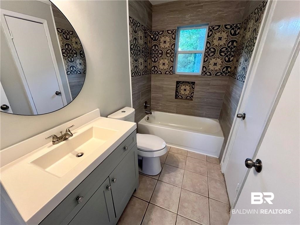 8636 Boe Road Irvington, AL 36544 - Photo 16 of 22 Bathroom featuring vanity, washtub / shower combination, and light tile patterned flooring