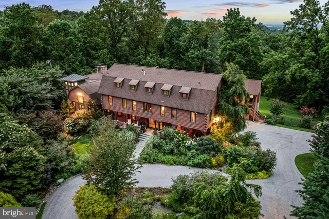 an aerial view of a house with yard and green space