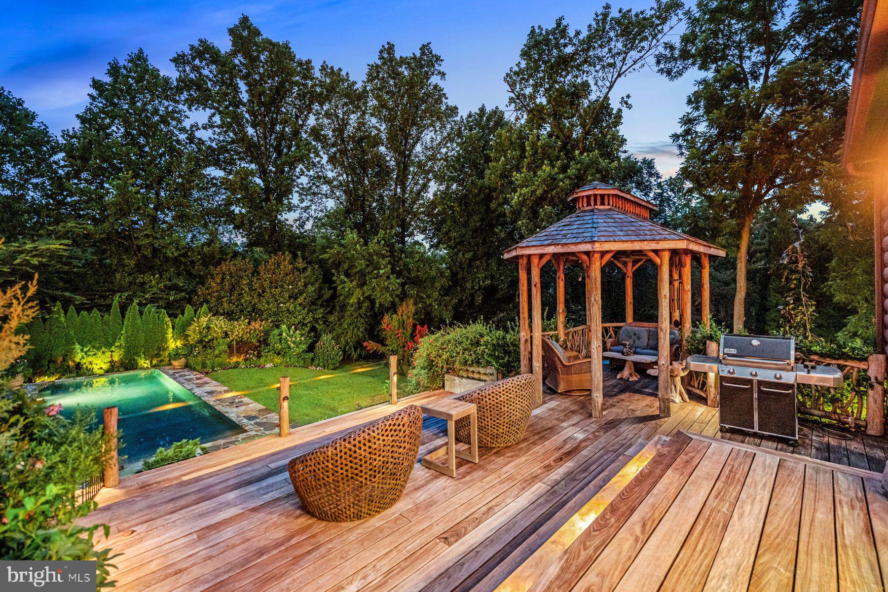 1408 Rene Road Villanova, PA 19085 - Photo 6 of 66 a view of a patio with table and chairs under an umbrella with wooden floor
