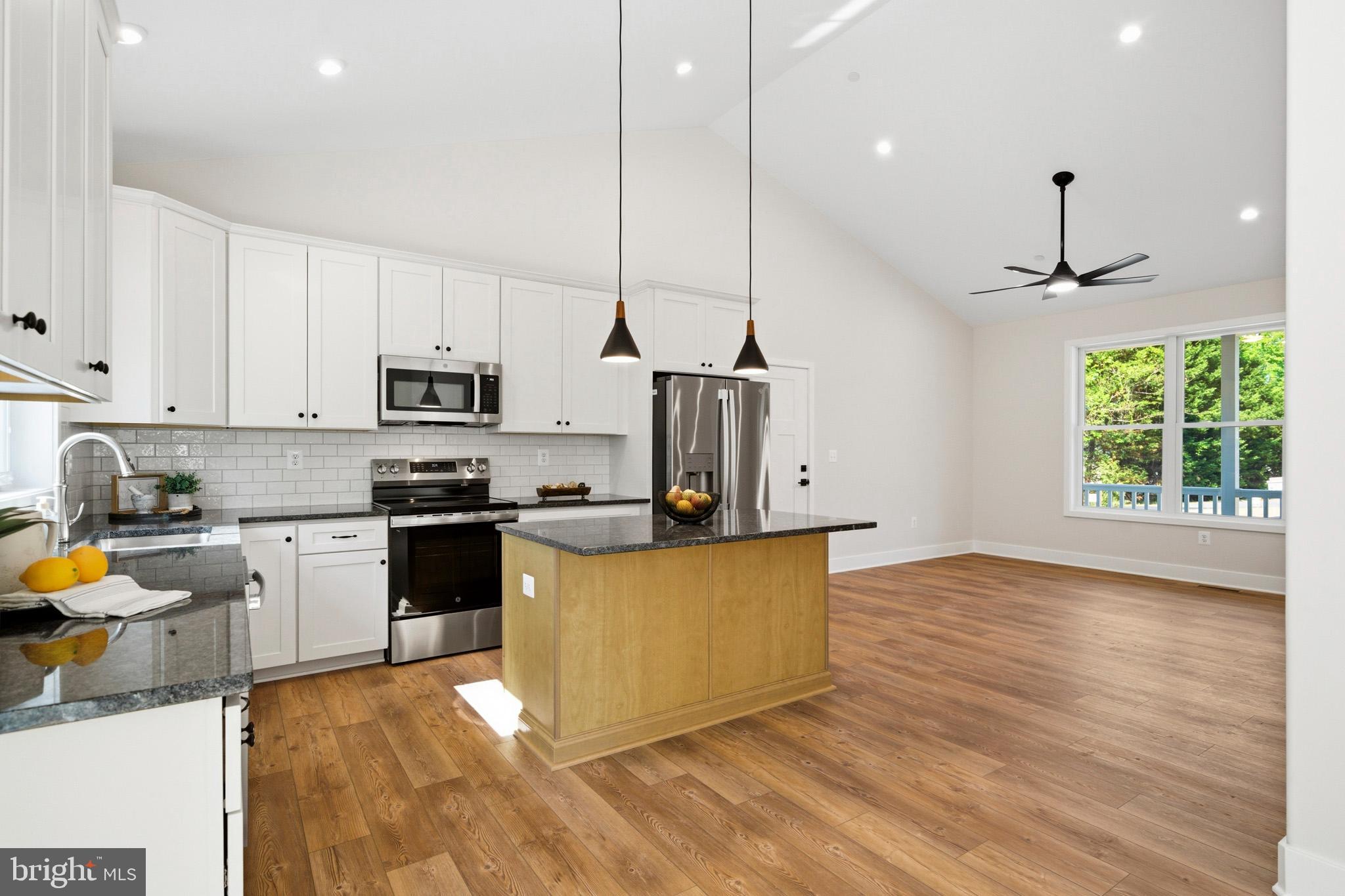 1362 Solomons Island Road Huntingtown, MD 20639 - Photo 13 of 37 a kitchen with stainless steel appliances granite countertop a sink a stove and a wooden floors