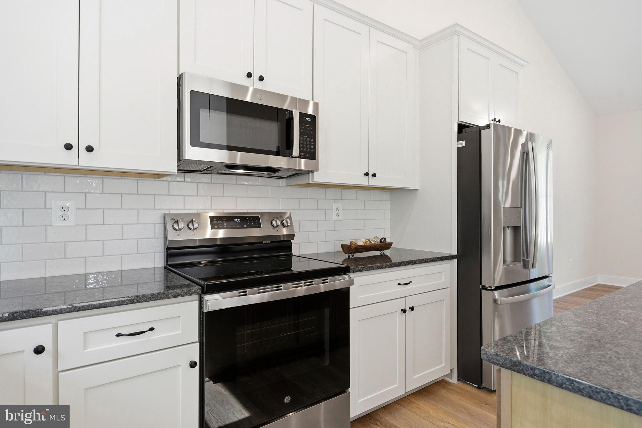 1362 Solomons Island Road Huntingtown, MD 20639 - Photo 16 of 37 a kitchen with white cabinets and stainless steel appliances