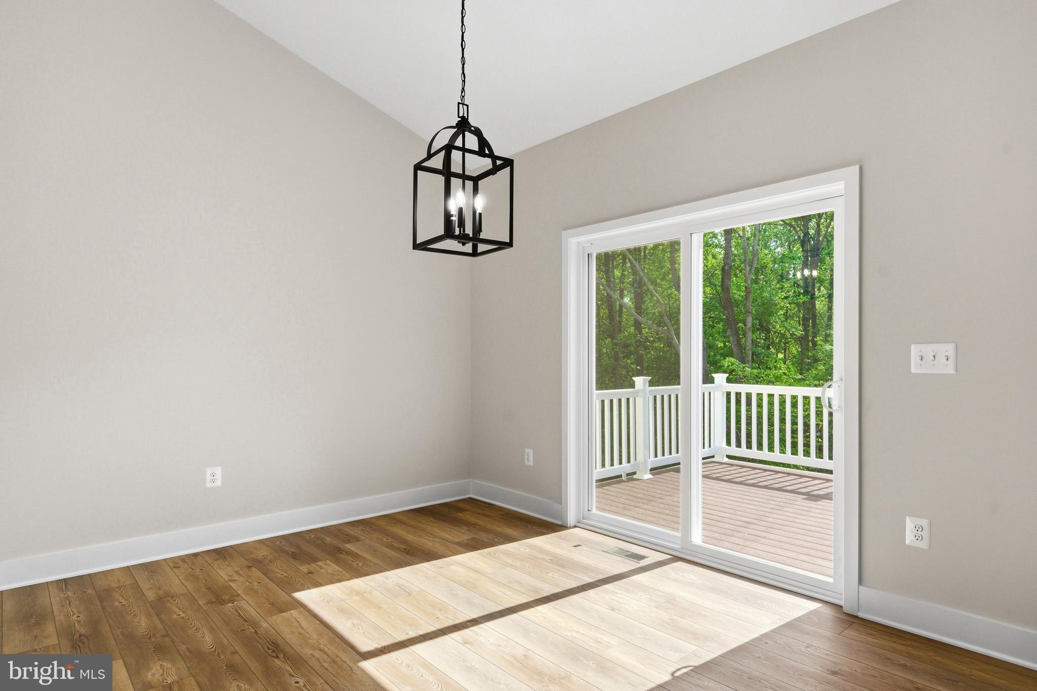 1362 Solomons Island Road Huntingtown, MD 20639 - Photo 17 of 37 a view of a room with wooden floor chandelier and windows