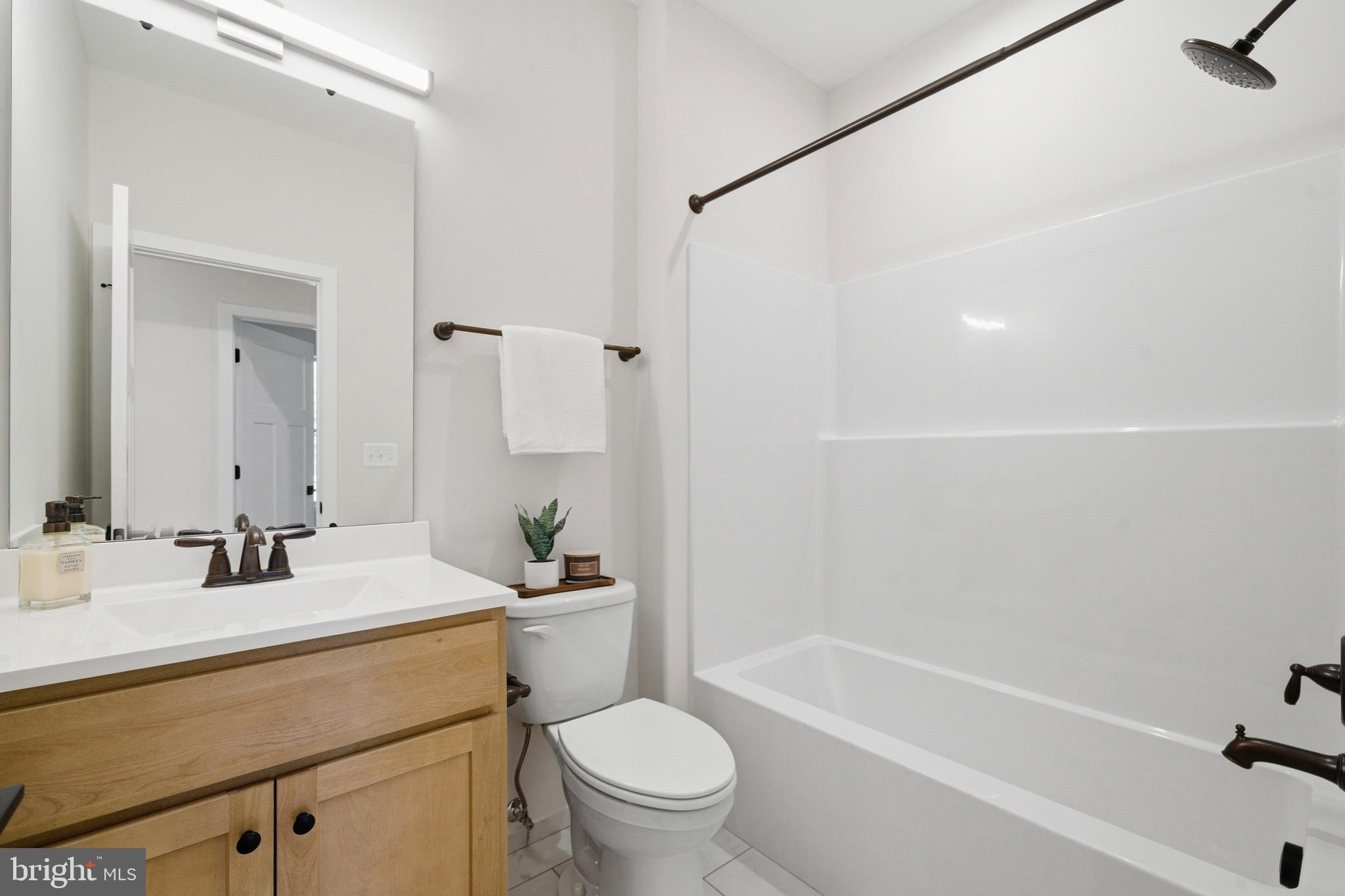 1362 Solomons Island Road Huntingtown, MD 20639 - Photo 21 of 37 a bathroom with a sink a toilet and a mirror